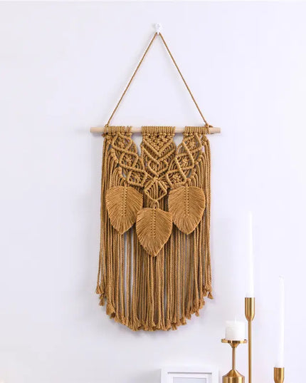 Macrame wall hanging with leaf patterns on a white wall