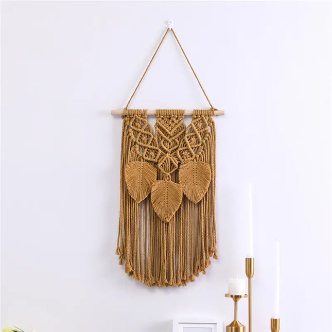 Macrame wall hanging with leaf patterns on a white wall