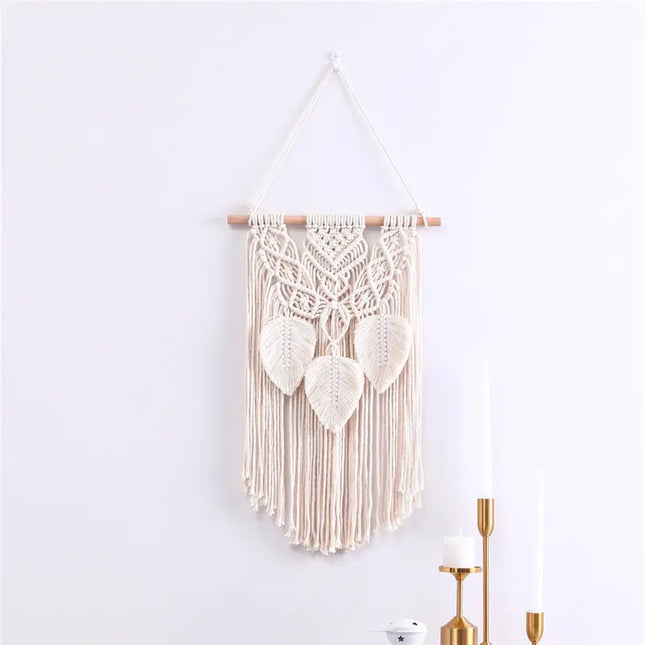 Macrame wall hanging with leaf patterns on a white wall