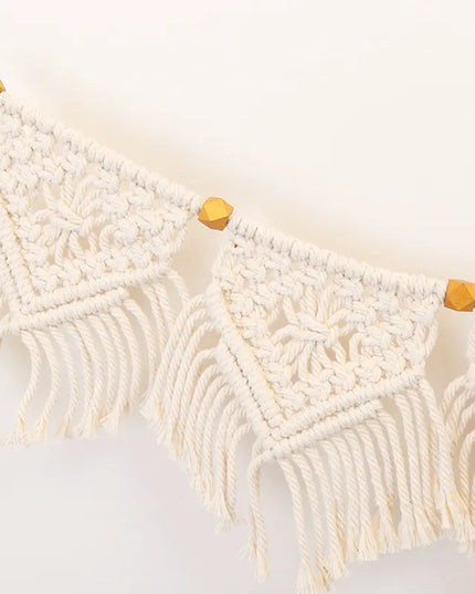 Macrame wall hanging with wooden beads on a white background