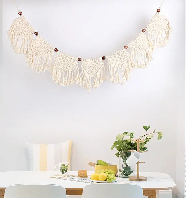 Macrame wall hanging above a dining table with decor items.