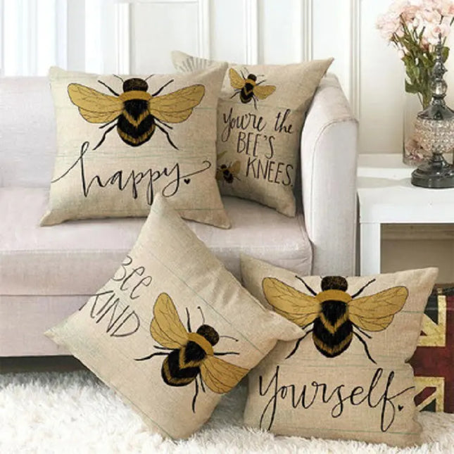 Decorative pillows with bee illustrations and text on a couch.