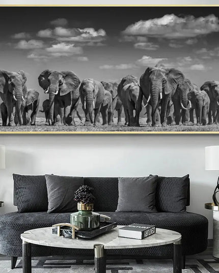 Framed artwork of elephants on a wall above a dark gray sofa in a living room.