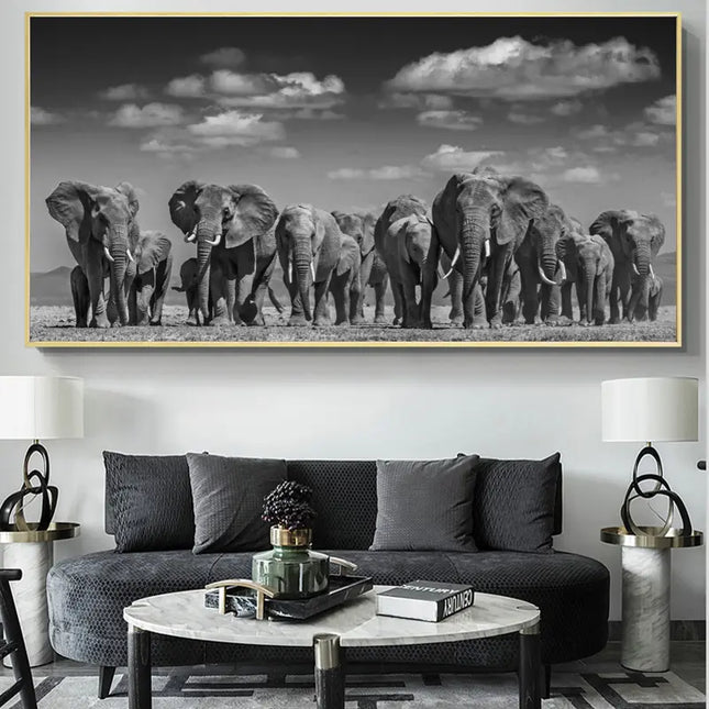 Framed artwork of elephants on a wall above a dark gray sofa in a living room.