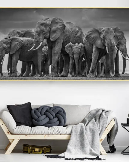 Framed black and white photograph of elephants on a wall above a sofa.