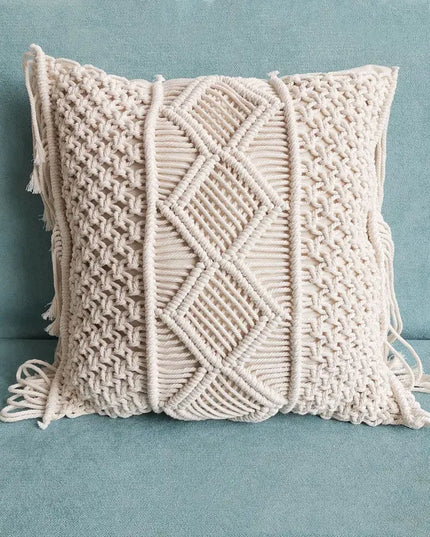 Beige macrame pillow with geometric pattern on a light blue background