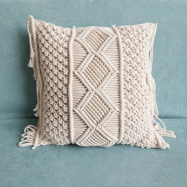 Beige macrame pillow with geometric pattern on a light blue background