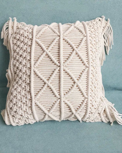 Macrame pillow with geometric pattern and tassels on a blue background