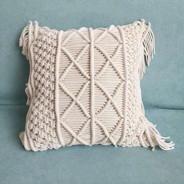 Macrame pillow with geometric pattern and tassels on a blue background