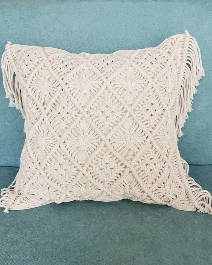 Macrame pillow with fringe on a teal couch