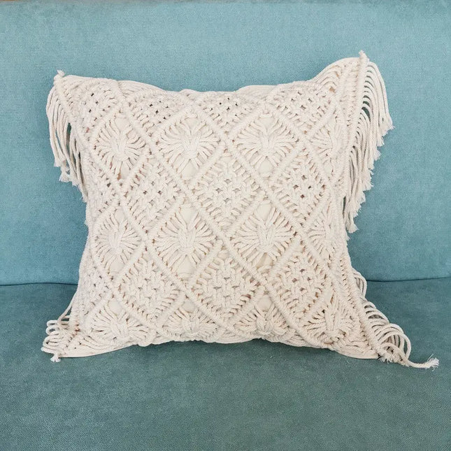 Macrame pillow with fringe on a teal couch