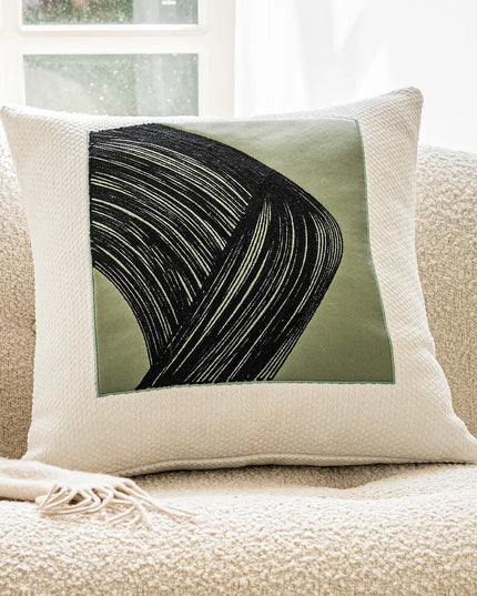 Decorative pillow with abstract design on a beige couch