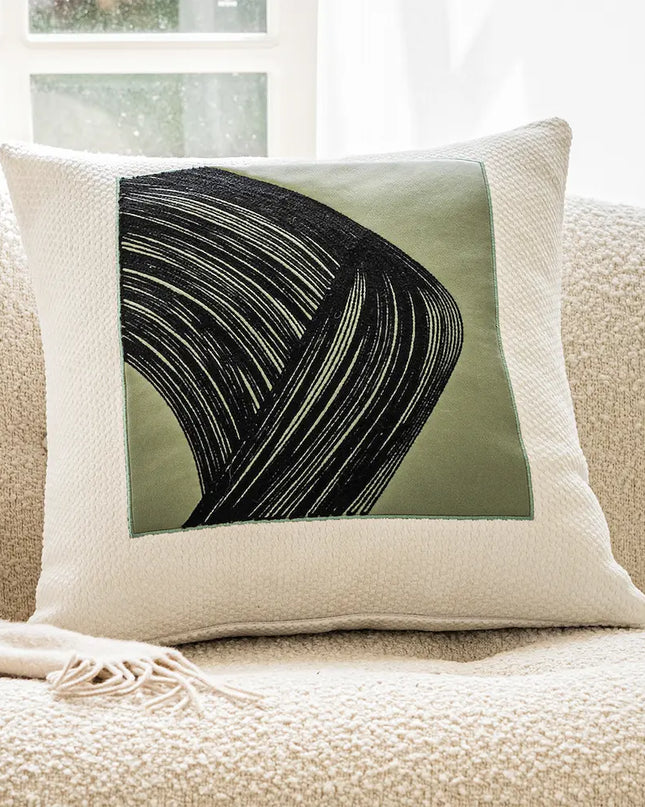 Decorative pillow with abstract design on a beige couch