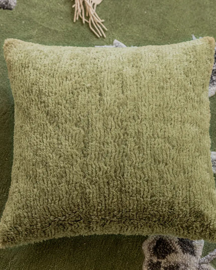 Green textured pillow on a green background with decorative elements.