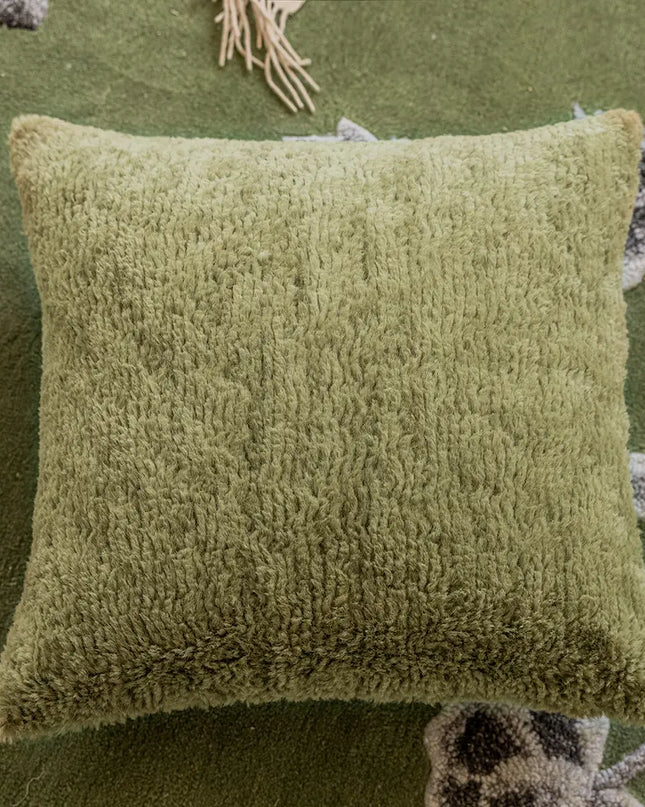 Green textured pillow on a green background with decorative elements.