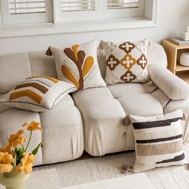 Beige sofa with decorative pillows and a vase of flowers in a living room setting.