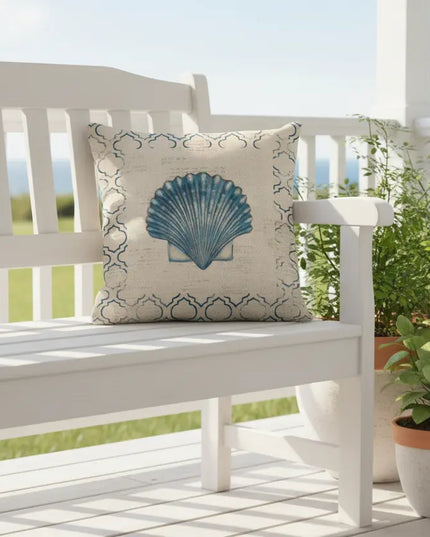 White bench with a decorative pillow featuring a blue shell design on a porch with plants.
