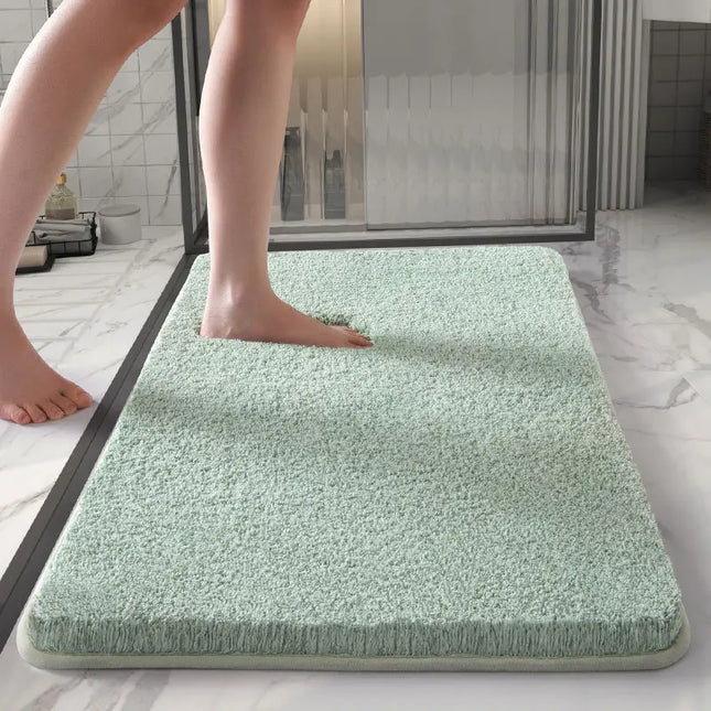 Person stepping onto a green bath mat in a bathroom.