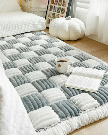 Gray and white checkered rug on a wooden floor with a cup and book on top