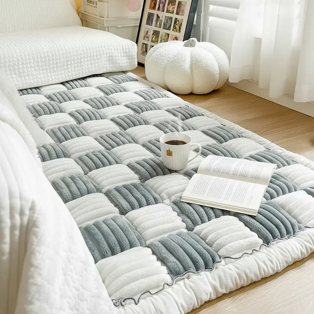 Gray and white checkered rug on a wooden floor with a cup and book on top
