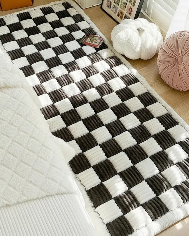 Black and white checkered rug on a wooden floor with decorative items around.