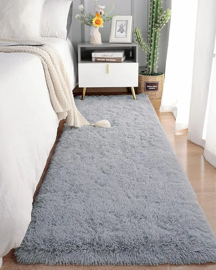 Fluffy gray bedside rug on a wooden floor in a cozy bedroom