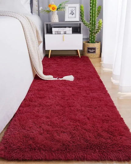 Fluffy red bedside rug on a wooden floor in a cozy bedroom