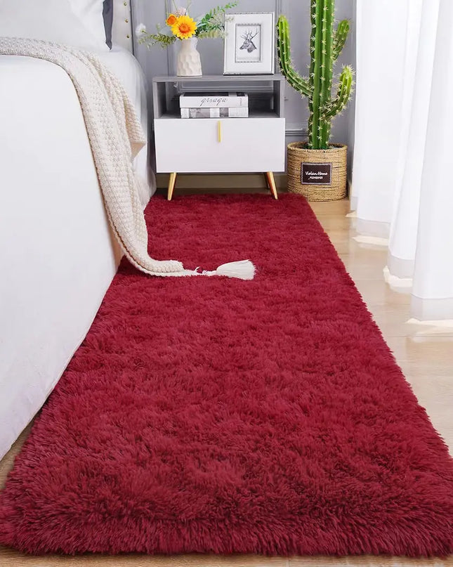 Fluffy red bedside rug on a wooden floor in a cozy bedroom
