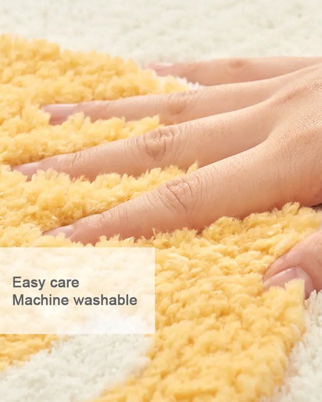 Yellow textured rug with hands touching it, labeled 'Easy care Machine washable'.