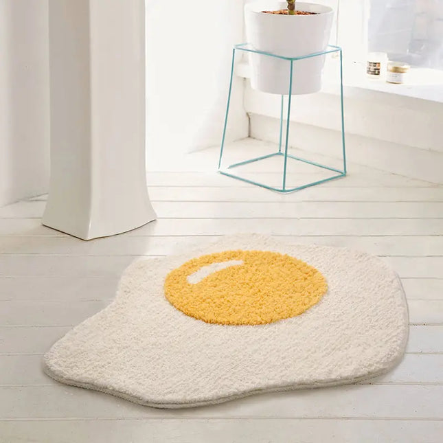 Poached edd design bath mat on a light wooden floor.