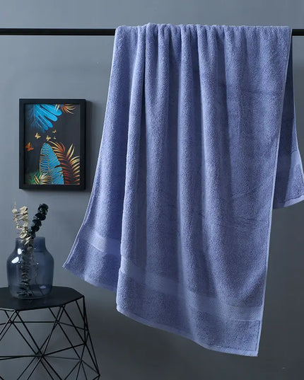 Blue towel hanging on a rack against a gray wall with a decorative vase and artwork.