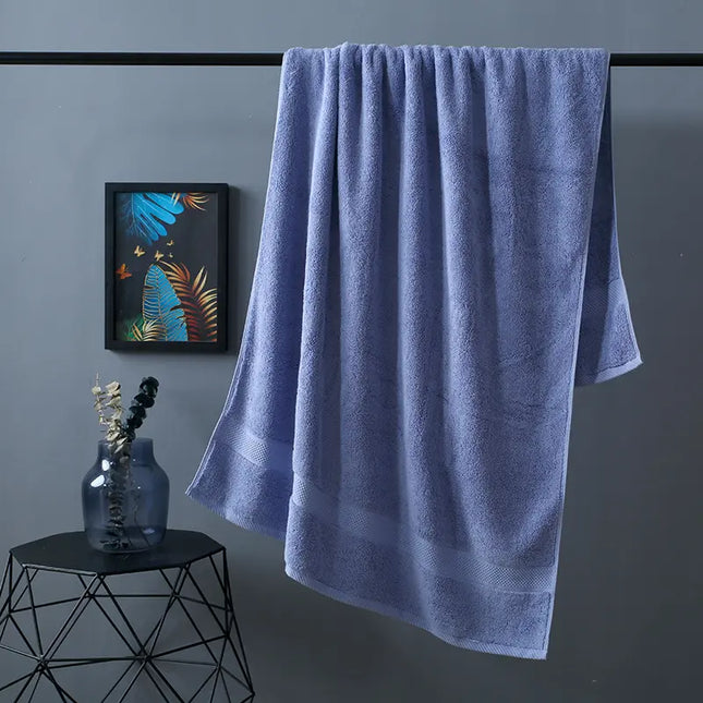 Blue towel hanging on a rack against a gray wall with a decorative vase and artwork.
