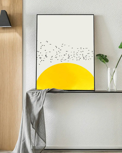 Poster with rising yellow sun and black flying birds on the white wall