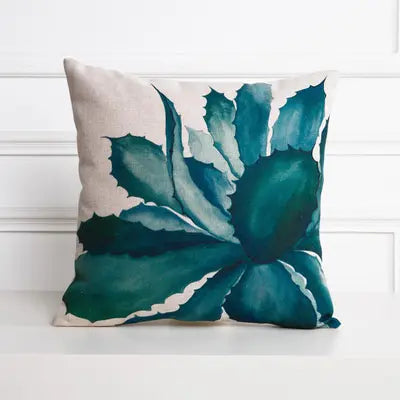 Decorative pillow with blue leaf pattern on a white background