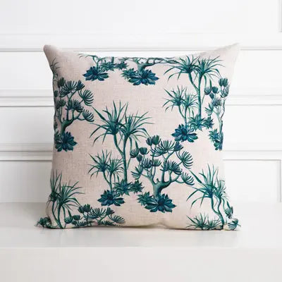 Decorative pillow with teal botanical pattern on a white background