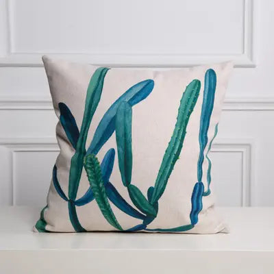 Decorative pillow with teal cactus design on a white background