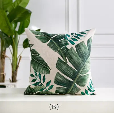Decorative pillow with green leaf pattern on a white surface