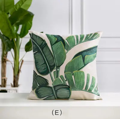 Decorative pillow with green leaf pattern on a white surface