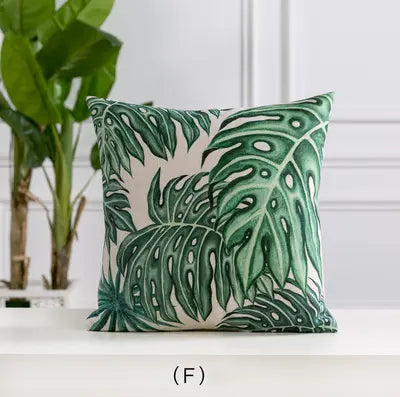 Decorative pillow with green leaf pattern on a white surface
