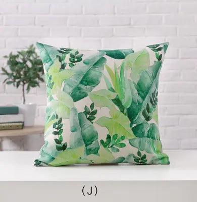 Decorative pillow with green leaf pattern on a white surface
