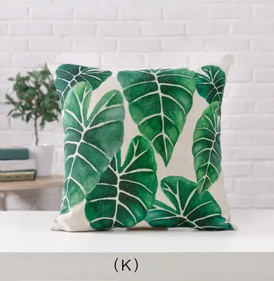Decorative pillow with green leaf pattern on a white background