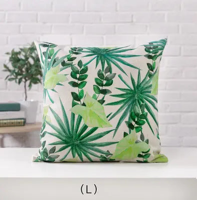 Decorative pillow with green leaf pattern on a white surface