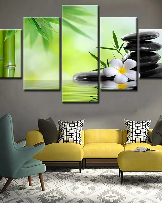 Living room with a yellow sofa, green armchair, and wall art featuring bamboo, stones, and a flower.