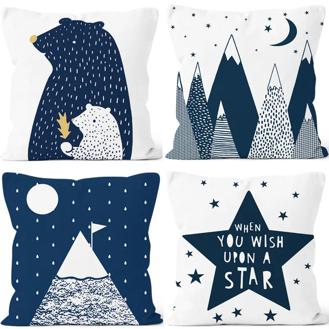 Four decorative pillows with bear, mountain, and star designs on a white background.